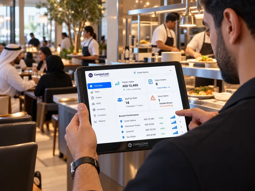 Restaurant branch manager reviewing live performance on a CompuCash tablet